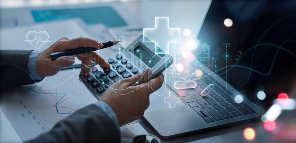 Médico em frente a um computador segurando uma calculadora