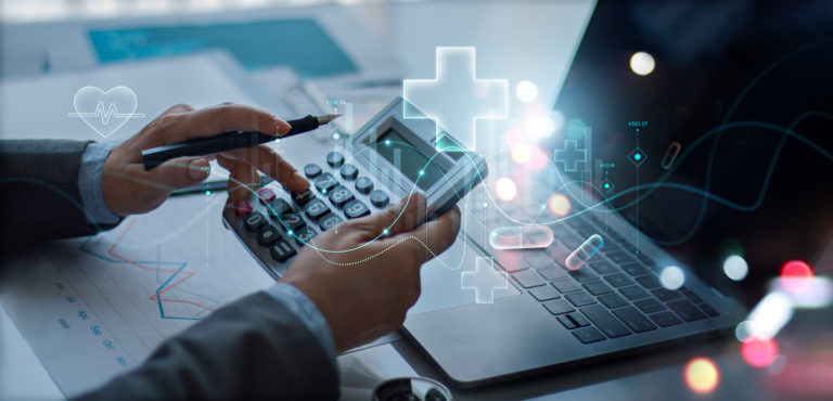Médico em frente a um computador segurando uma calculadora