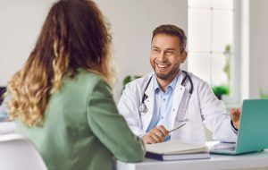 Médico em consulta com paciente em clínica, representando diálogo e suporte no atendimento
