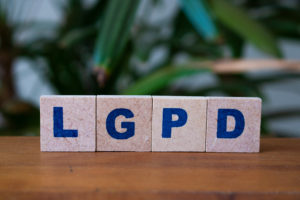 Sistemas de gestão em saúde: por que são importantes? 1 Dados sobre uma mesa com letras formando a palavra LGPD