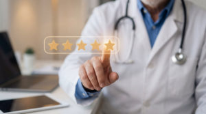 Plano de saúde para clínica: 4 dicas para contratar o ideal 1 Médico ao fundo apontando para um holograma de avaliação em estrelas