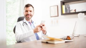 Instagram para médicos: conheça os 10 principais mitos 1 Médico em consultório usando o celular para usar o Instagram