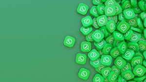 Lembretes de consulta por WhatsApp: reduza as faltas dos seus pacientes 1 Centenas tag verdes com a logo do WhatsApp juntas em fundo verde