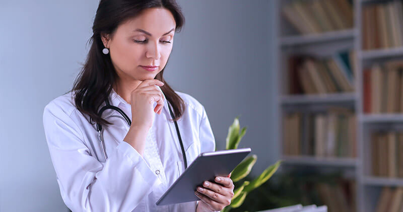 Qual a importância da margem de lucro para clínicas médicas? 4 margem de lucro medica olhando graficos no tablet