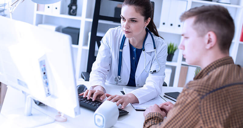 Saiba como conquistar novos pacientes para sua clínica médica! 6 conquistar novos pacientes medico e paciente analisando computador