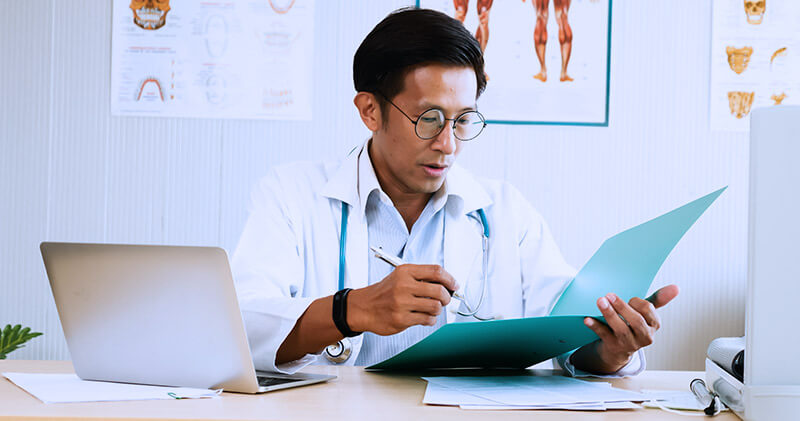 Como funciona um organizador de prontuários? 3 organizador de prontuarios medico analisando documentos do paciente