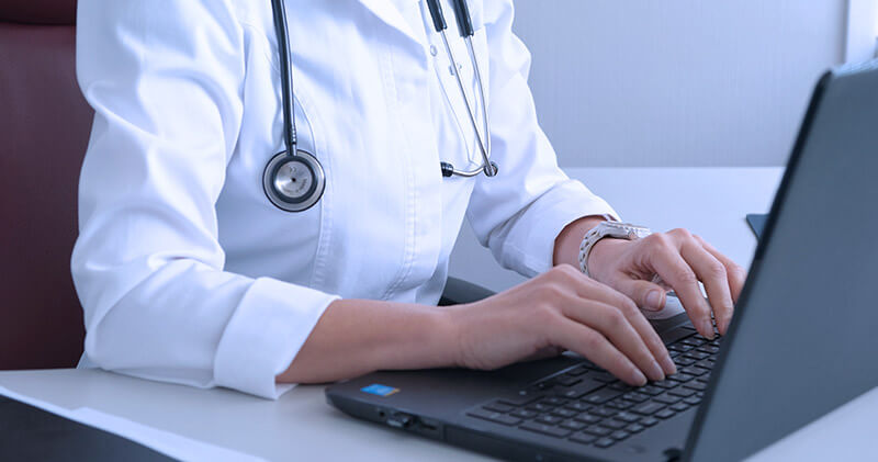 Veja os benefícios de ter um site médico e exemplos para você se inspirar! 7 site para medico medica mexendo no notebook