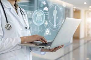Como o prontuário eletrônico personalizado transforma sua rotina clínica 1 Médica segurando notebook com prontuário eletrônico com várias informações em holograma