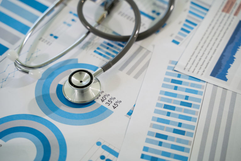 Médico analisando dados e gráficos virtuais relacionados a rentabilidade da clínica