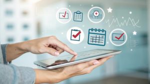 Gestão do tempo para médicos: otimização e prevenção de burnout 1 Médico segurando tablet com vários ícones holográficos de calendário e checklists sobre ele