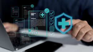 Checklist de segurança: como garantir a conformidade LGPD na rotina clínica 1 Médico sentado de frente para um notebook preenchendo um checklist holográfico