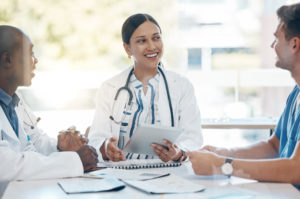 Médicos se reunindo em uma mesa para alinhar os indicadores de desempenho