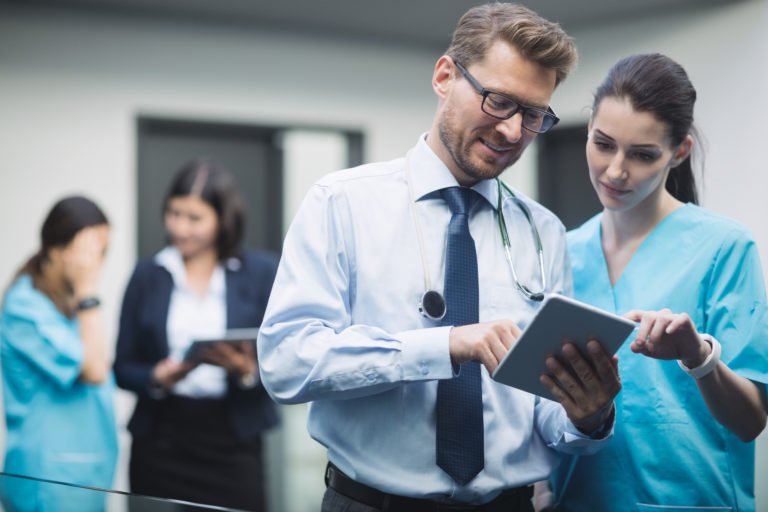 Médico e enfermeira utilizando tablet