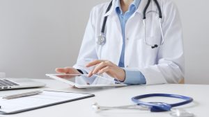 Impacto da prescrição digital na medicina 1 Médica em seu consultório usando o seu tablet para fazer a prescrição digital