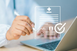 Assinatura digital na saúde: quando usar e como garantir validade jurídica 1 Médico em frente a um notebook realizando uma assinatura eletrônica